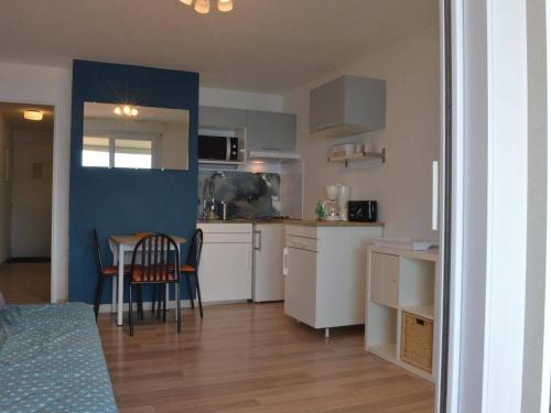 une cuisine avec des armoires blanches et une table et des chaises dans l'établissement Appartement 2 pièces avec climatisation et parking à Banyuls-sur-Mer - FR-1-225C-12, à Banyuls-sur-Mer