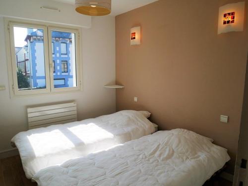 a bedroom with two beds and a window at Quiberon: Appartement 3 pièces avec balcon et parking près du centre - FR-1-478-37 in Quiberon