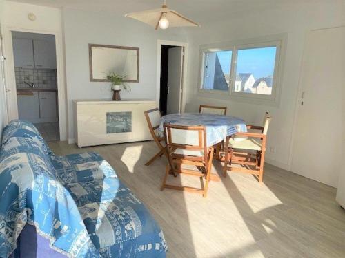 ein Wohnzimmer mit einem Sofa, einem Tisch und Stühlen in der Unterkunft Appartement Quiberon, 2 pièces, 3 personnes - FR-1-478-81 in Quiberon