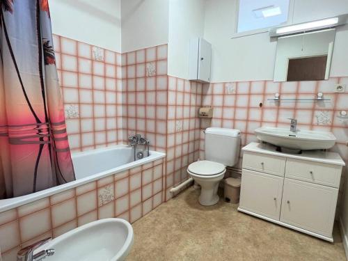 Un baño con lavabo, inodoro y bañera. en Charmant T1 Bis à Cambo-les-Bains avec balcon, ascenseur et parking - FR-1-495-31, en Cambo-les-Bains