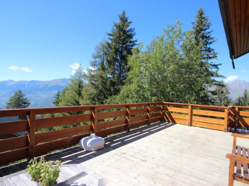 a deck with a fence and mountains in the background at Chalet confortable avec billard, cheminée et Wifi à Vallandry - FR-1-411-545 in Landry