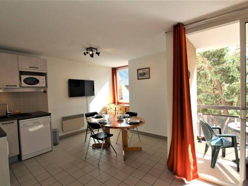 une cuisine et une salle à manger avec une table et des chaises dans l'établissement 2 pièces, parking, balcon sud, proche télécabine - Briançon - FR-1-330C-66, à Briançon
