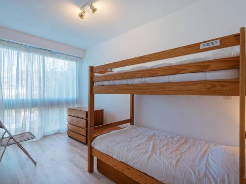 une chambre avec deux lits superposés et une fenêtre dans l'établissement Carnac: Appartement 6 pers, 3 pièces, 60m², Wifi, proche plage, parking - FR-1-477-29, à Carnac