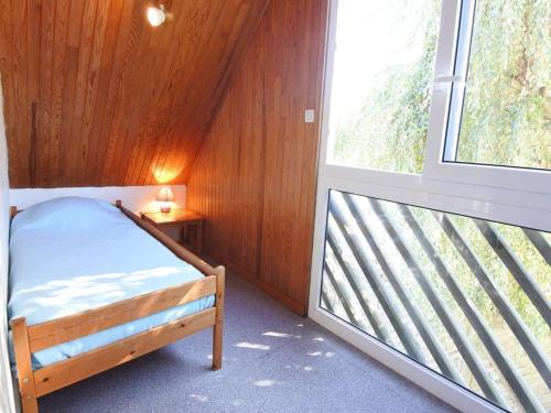 une petite chambre avec un lit et une fenêtre dans l'établissement Maison lumineuse à Carnac, 4 pièces, 55m², piscine chauffée, à 500m de la plage et des commerces, Wifi - FR-1-477-68, à Carnac