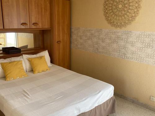 - une chambre avec un lit et 2 oreillers jaunes dans l'établissement Bel appartement lumineux avec balcon, proche des Thermes et commerces, animaux admis - FR-1-503-62, à Balaruc-les-Bains