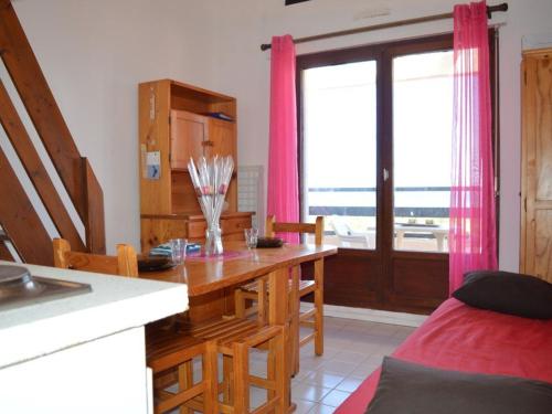 une cuisine avec une table et une salle à manger avec une fenêtre dans l'établissement Appartement 2 pièces avec mezzanine, piscine et parking à Saint Cyprien - FR-1-225D-65, à Saint Cyprien Plage