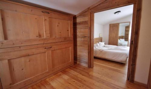 a bedroom with wooden walls and a bed with a mirror at Hotel La Meridiana in Madesimo