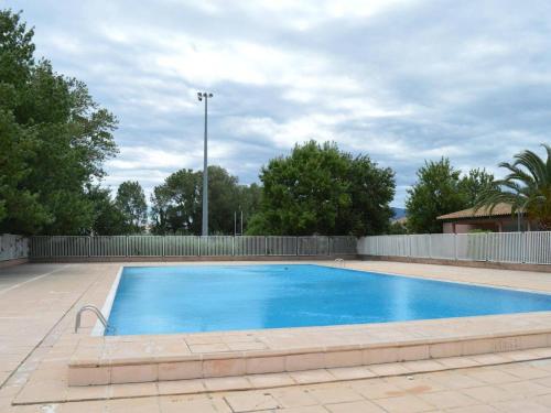 une grande piscine bleue avec une clôture dans l'établissement Appartement 3 Pièces à Saint-Cyprien : 6 Couchages, Piscine, Terrasse, Parking et WIFI - FR-1-225D-68, à Saint Cyprien Plage