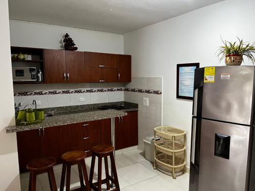 eine Küche mit einem Kühlschrank aus Edelstahl und Holzschränken in der Unterkunft Cabaña en coveñas in Coveñas