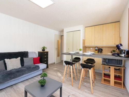 un salon avec un canapé et une cuisine dans l'établissement Appartement cosy 4 pers avec parking, proche centre, commerces et téléphérique - FR-1-296-279, à Saint-Lary-Soulan