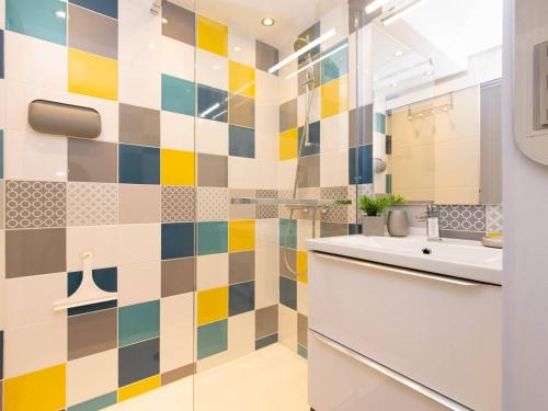 La salle de bains est pourvue d'un mur carrelé coloré. dans l'établissement Appartement cosy 4 pers avec parking, proche centre, commerces et téléphérique - FR-1-296-279, à Saint-Lary-Soulan