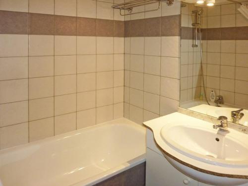 La salle de bains est pourvue d'une baignoire blanche et d'un lavabo. dans l'établissement Appartement Les Orres, 2 pièces, 6 personnes - FR-1-322-373, aux Orres