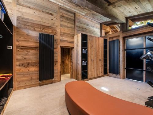 Zimmer mit Holzwänden und einem großen orangefarbenen Tisch in der Unterkunft Chalet luxe 5* pour 14 pers. à La Rosière avec hammam - FR-1-398-622 in Montvalezan