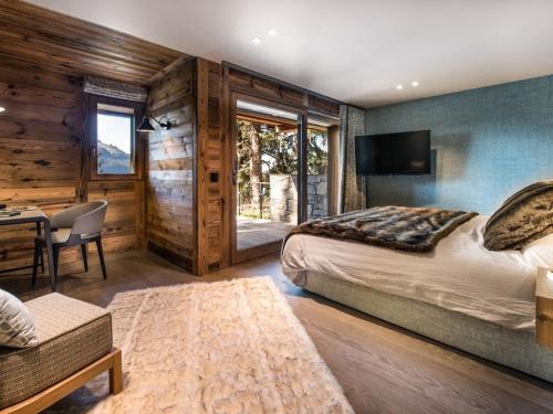 ein Schlafzimmer mit einem Bett, einem Schreibtisch und einem Fernseher in der Unterkunft Chalet luxe 5* pour 14 pers. à La Rosière avec hammam - FR-1-398-622 in Montvalezan