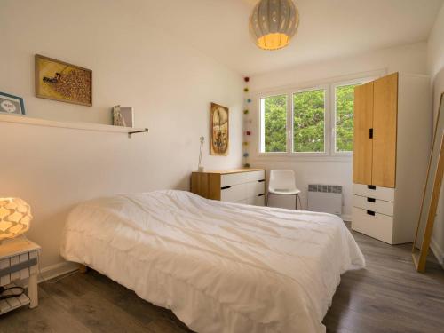 um quarto com uma cama, uma secretária e uma janela em Appartement Carnac, 3 pièces, 5 personnes - FR-1-477-30 em Carnac