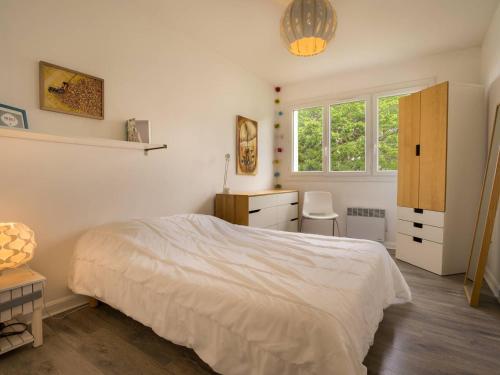a bedroom with a bed and a desk and a window at Carnac Plage: Grand 3P avec Loggia, Wifi, Parking, proche commerces et plage - FR-1-477-30 in Carnac