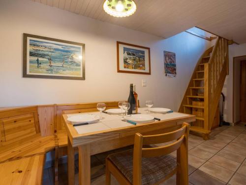 une salle à manger avec une table en bois et des verres à vin dans l'établissement Maison Charmante à Crac'h - 3 Pièces - 4 Pers - Wifi - Proche Plages - FR-1-477-42, à Crach