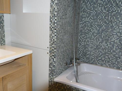 une salle de bain avec un lavabo et une baignoire dans l'établissement Appartement moderne 4 pièces, terrasse sud-ouest, 150m des pistes, 8 personnes, Arc 1800 - FR-1-411-600, à Arc 1800