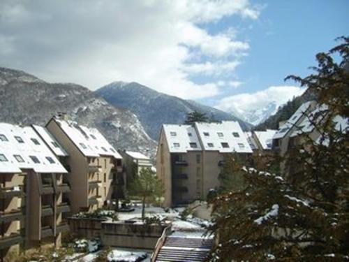 une ville enneigée avec des bâtiments et des montagnes en arrière-plan dans l'établissement Studio Cosy 2 Pers au Pied du Téléphérique - Balcon Sud, Parking, Wifi, Animaux Acceptés - FR-1-313-168, à Luchon