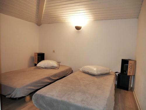 a room with two beds and a light on the wall at Villa Capbreton, 3 pièces, 4 personnes - FR-1-413-79 in Capbreton