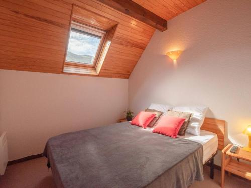 une chambre avec un lit avec deux oreillers rouges dans l'établissement Duplex 3 chambres près des télécabines et thermes, 8 pers. à Saint Lary - FR-1-296-286, à Saint-Lary-Soulan