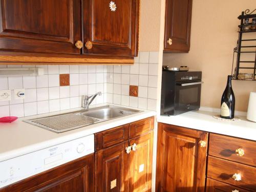 une cuisine avec des armoires en bois et un évier dans l'établissement Appartement à Montgenèvre, 5 couchages, balcon sud, parking, animaux admis, proche des pistes - FR-1-330D-121, à Montgenèvre