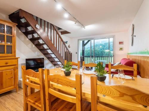 une salle à manger avec une grande table et des chaises en bois dans l'établissement Appartement duplex Saint-Lary 6 pers, 2 ch, mezzanine, balcon - FR-1-296-302, à Saint-Lary-Soulan