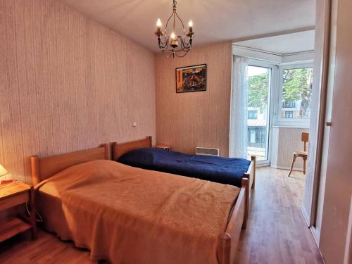 Schlafzimmer mit einem Bett und einem Kronleuchter in der Unterkunft Appartement Carnac, 3 pièces, 4 personnes - FR-1-477-133 in Carnac