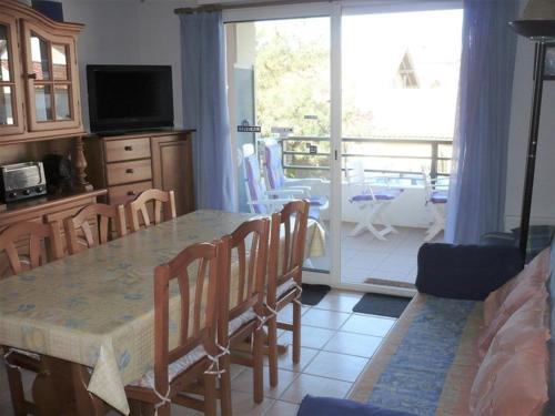 a living room with a table and chairs and a balcony at Appartement Vieux-Boucau-les-Bains, 2 pièces, 4 personnes - FR-1-379-97 in Vieux-Boucau-les-Bains