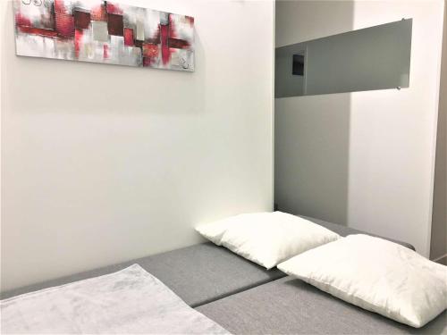 un lit avec deux oreillers dessus dans une chambre dans l'établissement Studio rénové avec balcon, quartier Saint Charles, à 800m de la plage du Miramar - FR-1-3-465, à Biarritz