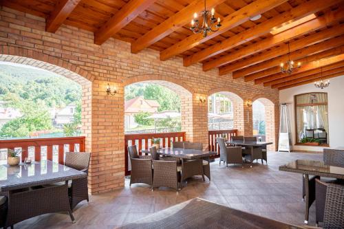 a restaurant with tables and chairs and a brick wall at Rezort Sivý Kameň in Podhradie