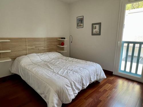 een slaapkamer met een bed in een kamer met een raam bij Appartement Cambo-les-Bains, 2 pièces, 2 personnes - FR-1-495-82 in Cambo-les-Bains