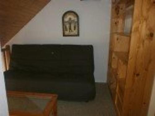 a black couch in a room with a picture on the wall at Appartement Saint-Lary-Soulan, 2 pièces, 6 personnes - FR-1-457-147 in Saint-Lary-Soulan