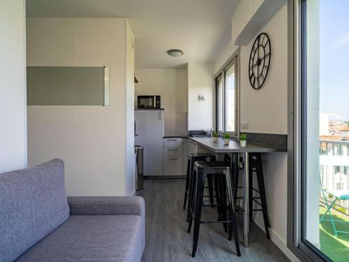 un salon avec un canapé et une cuisine dans l'établissement Studio rénové avec balcon, quartier Saint Charles, à 800m de la plage du Miramar - FR-1-3-465, à Biarritz