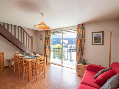 un salon avec un canapé rouge et une table dans l'établissement Duplex 3 chambres près des télécabines et thermes, 8 pers. à Saint Lary - FR-1-296-286, à Saint-Lary-Soulan