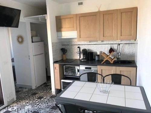 une petite cuisine avec une table et des chaises. dans l'établissement Villa T2, 4 pers, face à la mer, terrasse, parking privé, à 400m des commerces, plage devant! - FR-1-81-462, à Port-Leucate