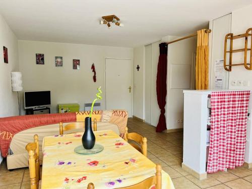 - un salon avec une table et un vase dans l'établissement Appartement F2 à Cambo-les-Bains avec piscine, proche thermes, terrasse et parking - FR-1-495-36, à Cambo-les-Bains