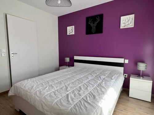 1 dormitorio con 1 cama con pared morada en Appartement Itxassou, 2 pièces, 3 personnes - FR-1-495-47, en Itxassou