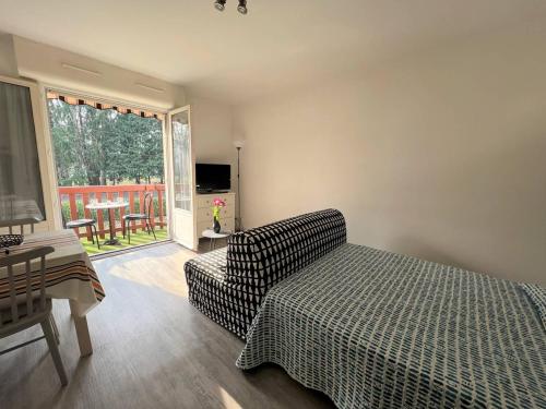 a living room with a couch and a table and a television at Appartement Cambo-les-Bains, 1 pièce, 2 personnes - FR-1-495-50 in Cambo-les-Bains