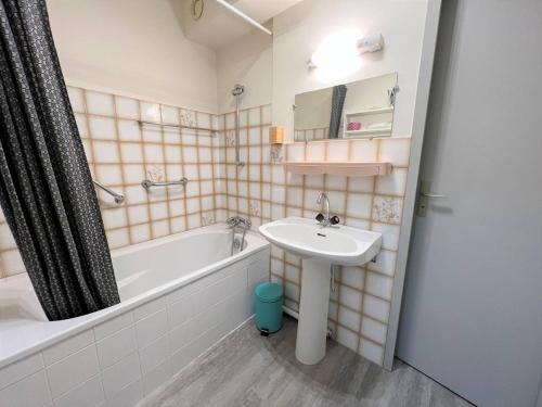 La salle de bains est pourvue d'un lavabo et d'une baignoire. dans l'établissement Appartement Cambo-les-Bains, 1 pièce, 2 personnes - FR-1-495-50, à Cambo-les-Bains
