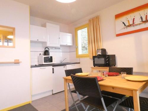 une cuisine et une salle à manger avec une table et des chaises dans l'établissement Studio cosy pour 4 avec terrasse à Saint-Lary-Soulan - FR-1-457-277, à Saint-Lary-Soulan
