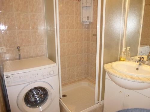 une salle de bain avec une machine à laver et un lavabo dans l'établissement Appartement 2 pièces, balcon, parking, animaux admis, plage à pied - FR-1-224C-58, à Saint-Hilaire-de-Riez