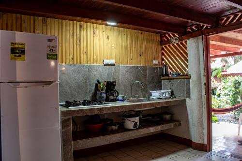 a kitchen with a white refrigerator and a counter at Chalet Y Cabinas Hibiscus in Cahuita