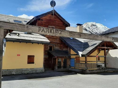 Un bâtiment avec un panneau indiquant le stationnement sur lui dans l'établissement Montgenèvre - Studio 4 pers. à 50m des pistes, parking, lumineux, wifi possible - FR-1-330D-57, à Montgenèvre