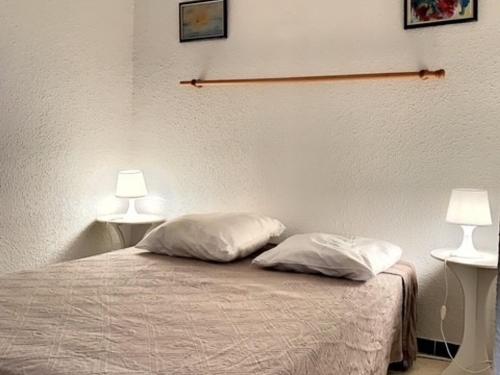 - une chambre avec 2 oreillers sur un lit et 2 lampes dans l'établissement T2 Cosy avec Balcon, Clim, Animaux Acceptés - FR-1-503-32, à Balaruc-les-Bains