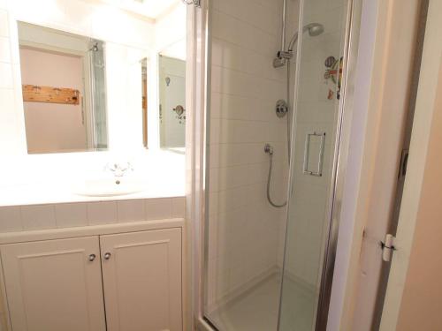 une salle de bain avec une douche, un lavabo et un miroir dans l'établissement Appartement familial sur les pistes avec parking et casier à skis - Montgenèvre - FR-1-330D-91, à Montgenèvre