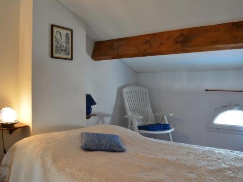une chambre avec un lit, une chaise et une fenêtre dans l'établissement Locations Saint-Cyprien: Appartement 2 pièces avec parking, terrasses, et loggia - FR-1-225D-35, à Saint Cyprien Plage