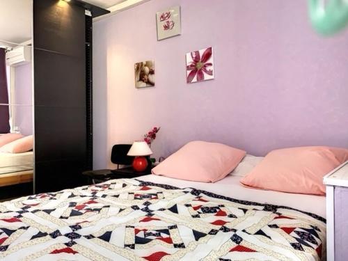 une chambre avec un lit avec une couette dessus dans l'établissement Appartement lumineux avec WIFI, climatisation et parking proche des Thermes - FR-1-503-63, à Balaruc-les-Bains