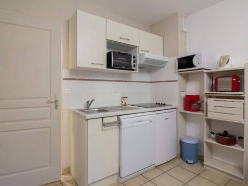 une petite cuisine avec un évier et un micro-ondes dans l'établissement Chalet triplex pour 7 pers. avec terrasse, parking, proche télécabine et commerces - FR-1-401-178, à Cauterets