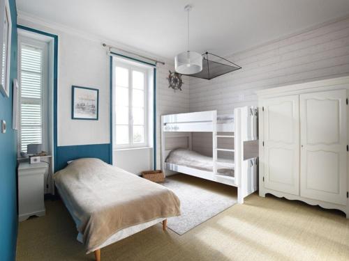 ein Schlafzimmer mit einem weißen Etagenbett und einem Fenster in der Unterkunft Appartement Ars-en-Ré, 3 pièces, 4 personnes - FR-1-434-54 in Ars-en-Ré